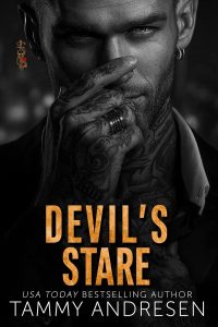 The book cover is black and white, with a man with tattoos in a suit, his hand over his nose, his eyes light. One of his fingers has a ring on it. The title Devil's Stare is in textured orange letters. Below it is the author's name in white, Tammy Andresen.